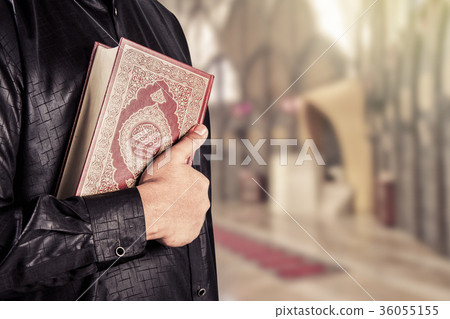 Koran with muslims man .Koran-holy book of Muslims Koran with muslims man .Koran-holy book of Muslims 36055155