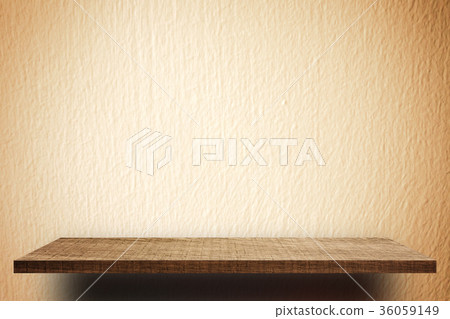 Empty wooden shelf on yellow cement wall  36059149