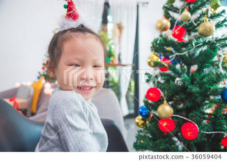 Little girl decorating christmas tree at home 36059404