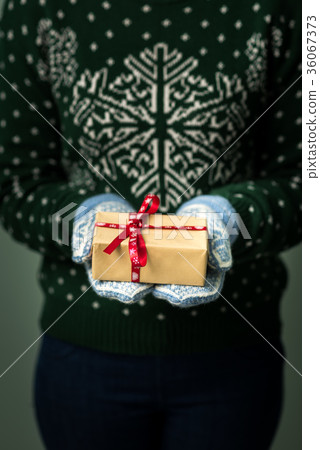 A girl holding a box with a Christmas present 36067373