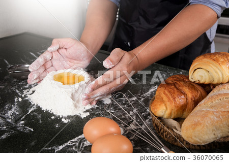 Woman's hands knead dough with flour, eggs and ingredients. at k 36070065