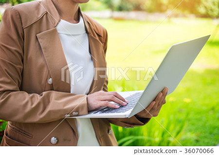 business woman hand using laptop on table in garden. business woman hand using laptop on table in garden. 36070066