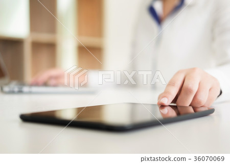 young female manager using modern digital tablet at office, typi 36070069