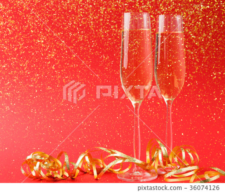 Champagne flutes on red holiday background Champagne flutes on red holiday background 36074126
