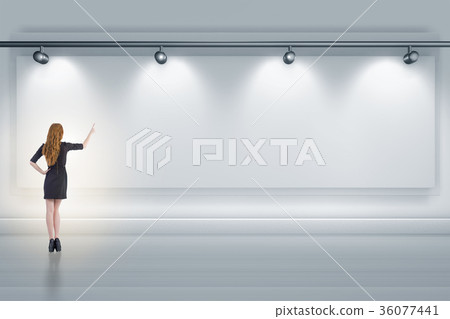 Businesswoman pressing virtual button on the wall Businesswoman pressing virtual button on the wall 36077441