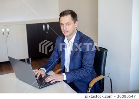 Young man working in office, sitting at desk Young man working in office, sitting at desk 36090547
