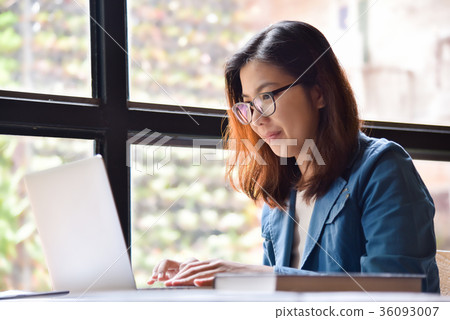 Woman in blue shirt smiling next to the window. 36093007