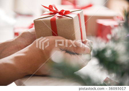 Male hands holding a brown present box. Male hands holding a brown present box. 36093017