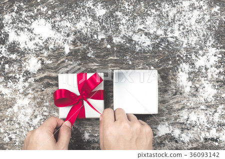 Man’s hand wrapping empty white Christmas gift. Man’s hand wrapping empty white Christmas gift. 36093142
