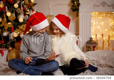 Excited children near Christmas tree Excited children near Christmas tree 36094708