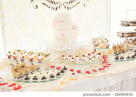 Delicious and tasty dessert table with cupcakes Delicious and tasty dessert table with cupcakes 36094930