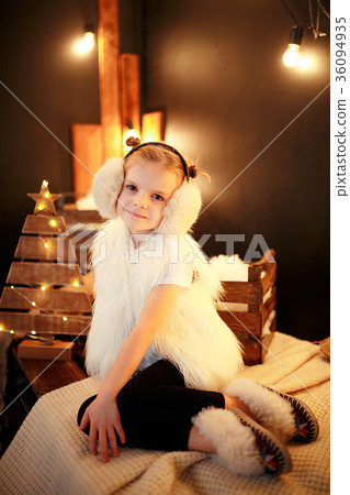 Cute little girl in fur earmuffs sitting near Cute little girl in fur earmuffs sitting near 36094935