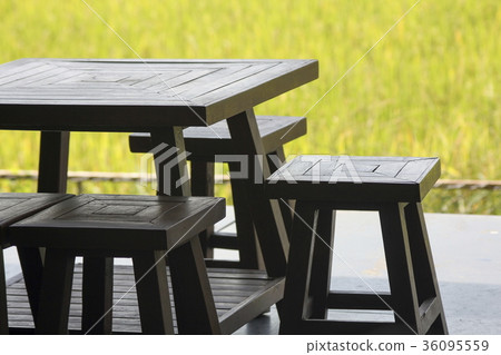Wood Table and chairs with yellow grass field. 36095559