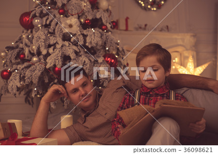 Father with son at home on Christmas evening Father with son at home on Christmas evening 36098621