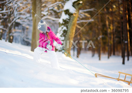 Funny little girl having fun with a sleight in winter park 36098795