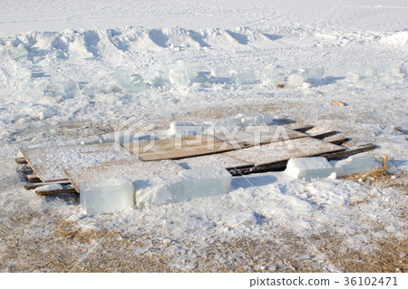 The hole in the ice closed with boards 36102471