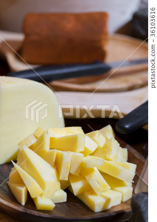 Slice gouda cheese on plate wooden table. 36103616