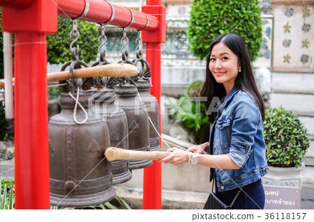 Woman ringing a bell in a Buddhist temple Woman ringing a bell in a Buddhist temple 36118157