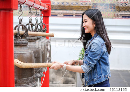 Woman ringing a bell in a Buddhist temple 36118165