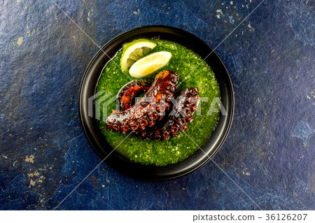 Grilled octopus serves with grin sauce on black Grilled octopus serves with grin sauce on black 36126207