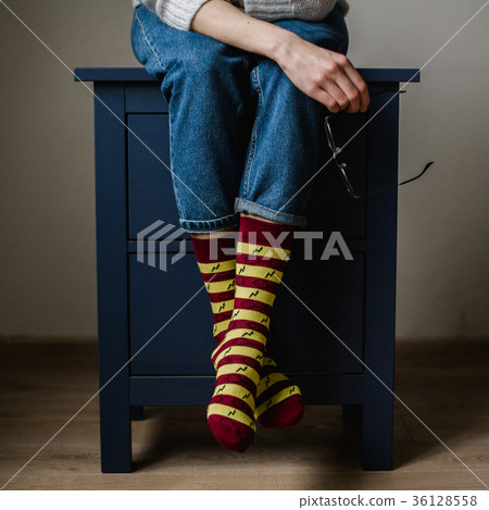 Feet in woollen socks. Woman is relaxing with a 36128558