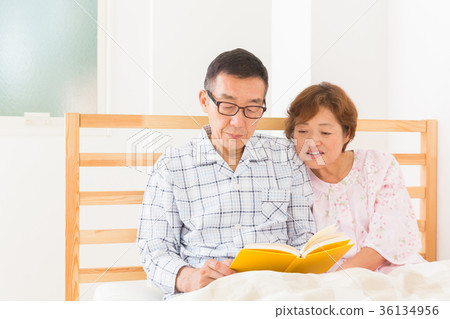 Senior couple reading a book Bed 36134956