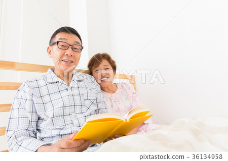 Senior couple reading a book Bed 36134958