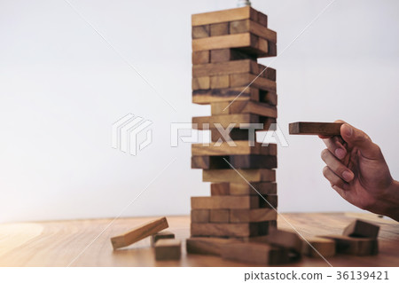 Images of hand of businesspeople placing and pulling wood block 36139421
