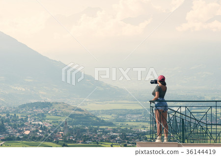 A female photographer with a camera on the balcony A female photographer with a camera on the balcony 36144419