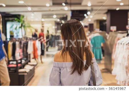 Young asian woman walking in clothes store Young asian woman walking in clothes store 36145967