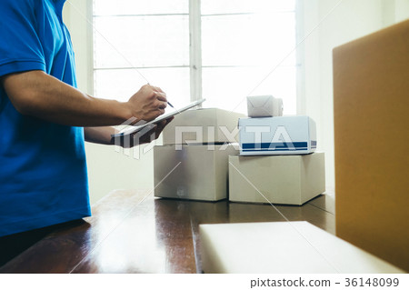 Courier making notes in delivery receipt. 36148099