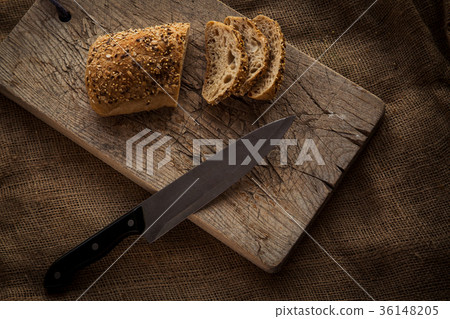 Wooden cutting board with sliced bread Wooden cutting board with sliced bread 36148205