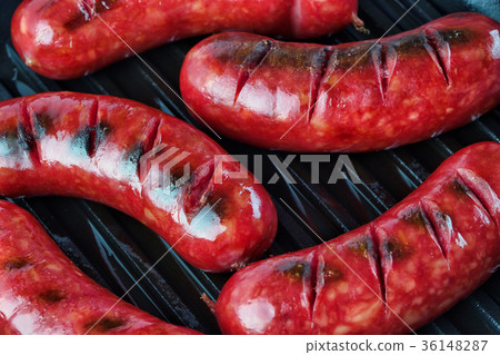 Fried sausages with golden crust on the grill 36148287