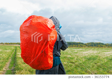 Backpacker on green field.Man hiking with backpack Backpacker on green field.Man hiking with backpack 36153774