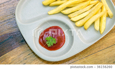 ketchup and french fries on a wooden table. 36156260