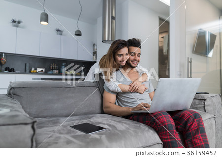 Couple Use Laptop Computer Together In Living Room Couple Use Laptop Computer Together In Living Room 36159452