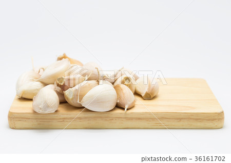 Garlic on wooden board over white 36161702