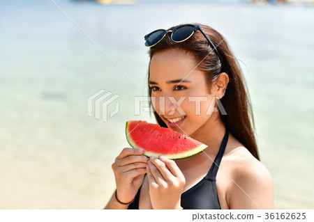 Beautiful girl wearing swimsuit eating watermelon beach. Beautiful girl wearing swimsuit eating watermelon beach. 36162625