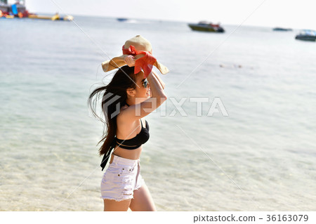 Beautiful woman wearing a swimsuit playing in the beach. 36163079