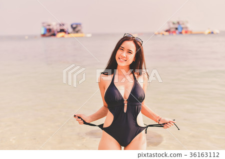 Beautiful woman wearing a swimsuit playing in the beach. 36163112