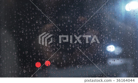 closeup of raindrops on window in night with 36164044