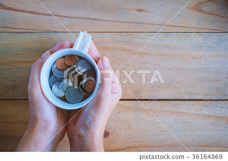 Hand holding a cup of Thai baht coins Hand holding a cup of Thai baht coins 36164869