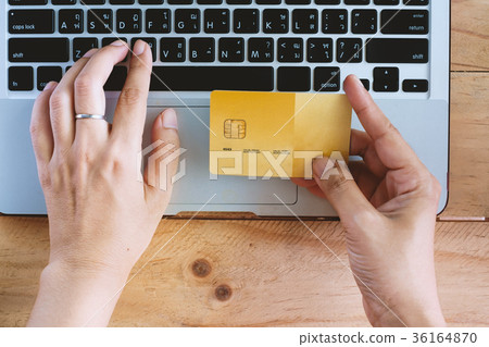 Hand holding a credit card and using computer 36164870