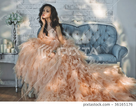 Beautiful lady in gorgeous couture dress on sofa 36165176