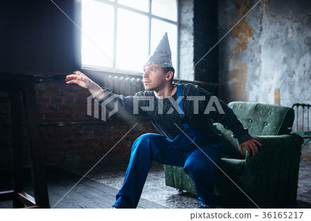 Strange man in tinfoil cap reaches out to TV, UFO Strange man in tinfoil cap reaches out to TV, UFO 36165217