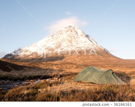 Green tent on meadow at river below snowy cone Green tent on meadow at river below snowy cone 36166161