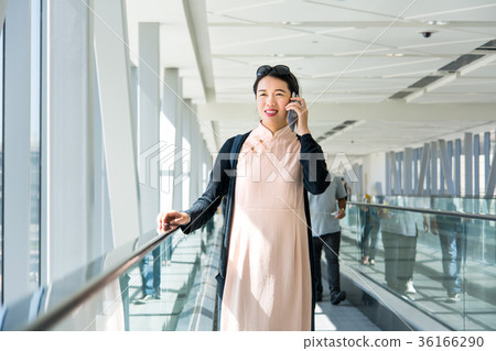 Girl using phone while on the travelator inside 36166290