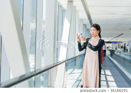 Girl taking picture while on the moving walkway 36166291