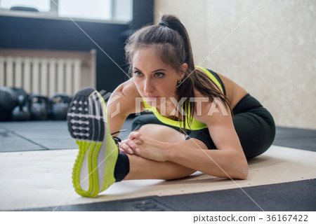 young fit woman doing seated forward fold exercise 36167422