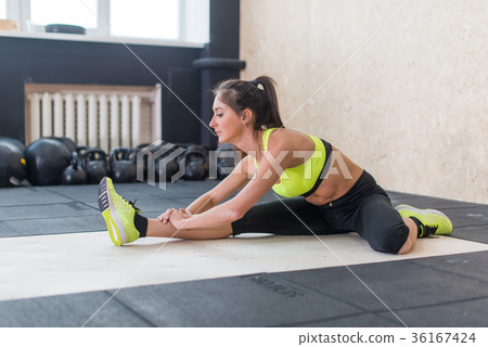 young woman stretching hamstring in gym, fit young woman stretching hamstring in gym, fit 36167424